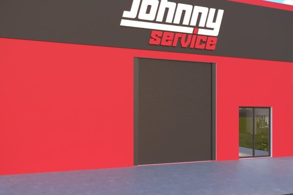 Um moderno edifício vermelho e preto com uma grande placa onde se lê Johnny Service acima de uma ampla porta de garagem, com uma pequena porta de entrada de vidro à direita. Essa oficina estética automotiva fica sob um céu azul claro.